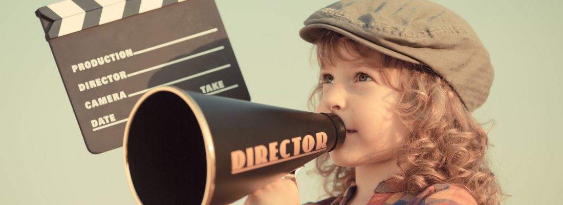 27585943 - kid holding clapper board against summer sky background. cinema concept